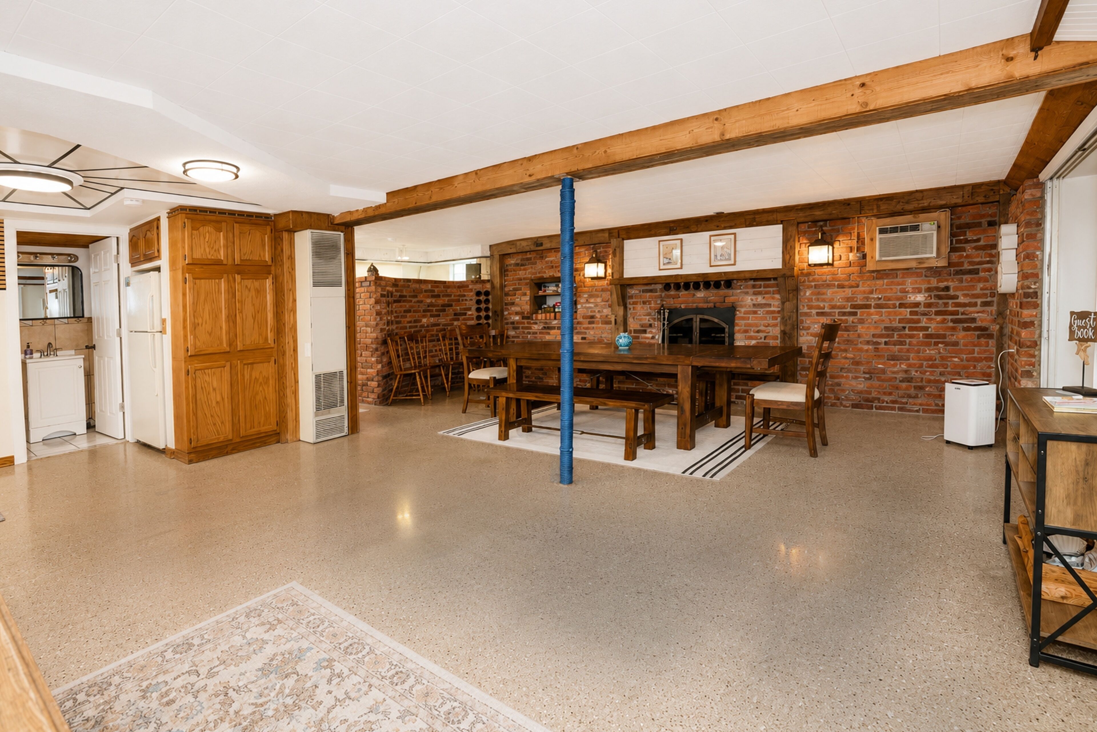 A spacious room with a dining area, a fireplace, and a kitchen.