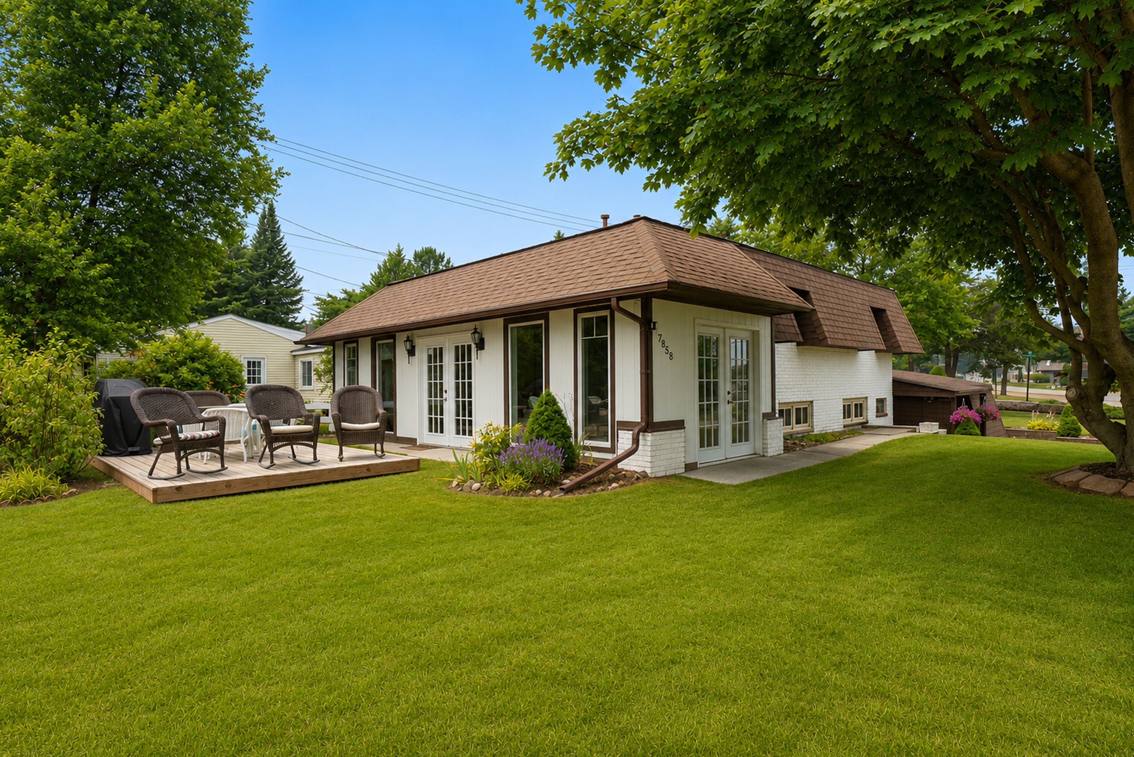 Une maison de plain-pied avec un porche à l’avant, un patio couvert aménagé avec du mobilier d’extérieur et une pelouse bien entretenue.