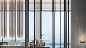 Un interior moderno con ventanas amplias, persianas verticales y vistas a un paisaje montañoso.