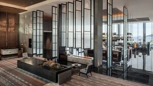 Un interior moderno con un amplio espacio abierto, una chimenea central y vistas al área de la cocina.