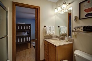 Een bad/douchecombinatie, een haardroger, handdoeken, zeep