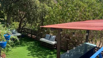 Relax in a serene outdoor space surrounded by lush greenery and a wooden fence.