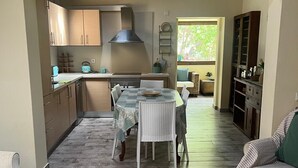A spacious kitchen with a dining area, wooden flooring, and a view to the outside. - Family retreat with private pool, be with your loved ones and create memories.... (São Bartolomeu de Messines)