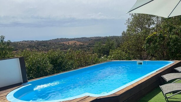 A swimming pool with a wooden deck and artificial grass, surrounded by greenery and a scenic view. - Family retreat with private pool, be with your loved ones and create memories.... (São Bartolomeu de Messines)