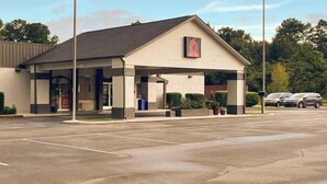 A motel with a covered parking area, a single-story structure, and a visible entrance. - Studio 6 Bay Minette, Al (Bay Minette)