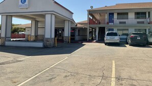 A building with a sign reading "Executive Inn & Suites" and a parking lot with several cars. - Executive Inn & Suites (Beaumont)