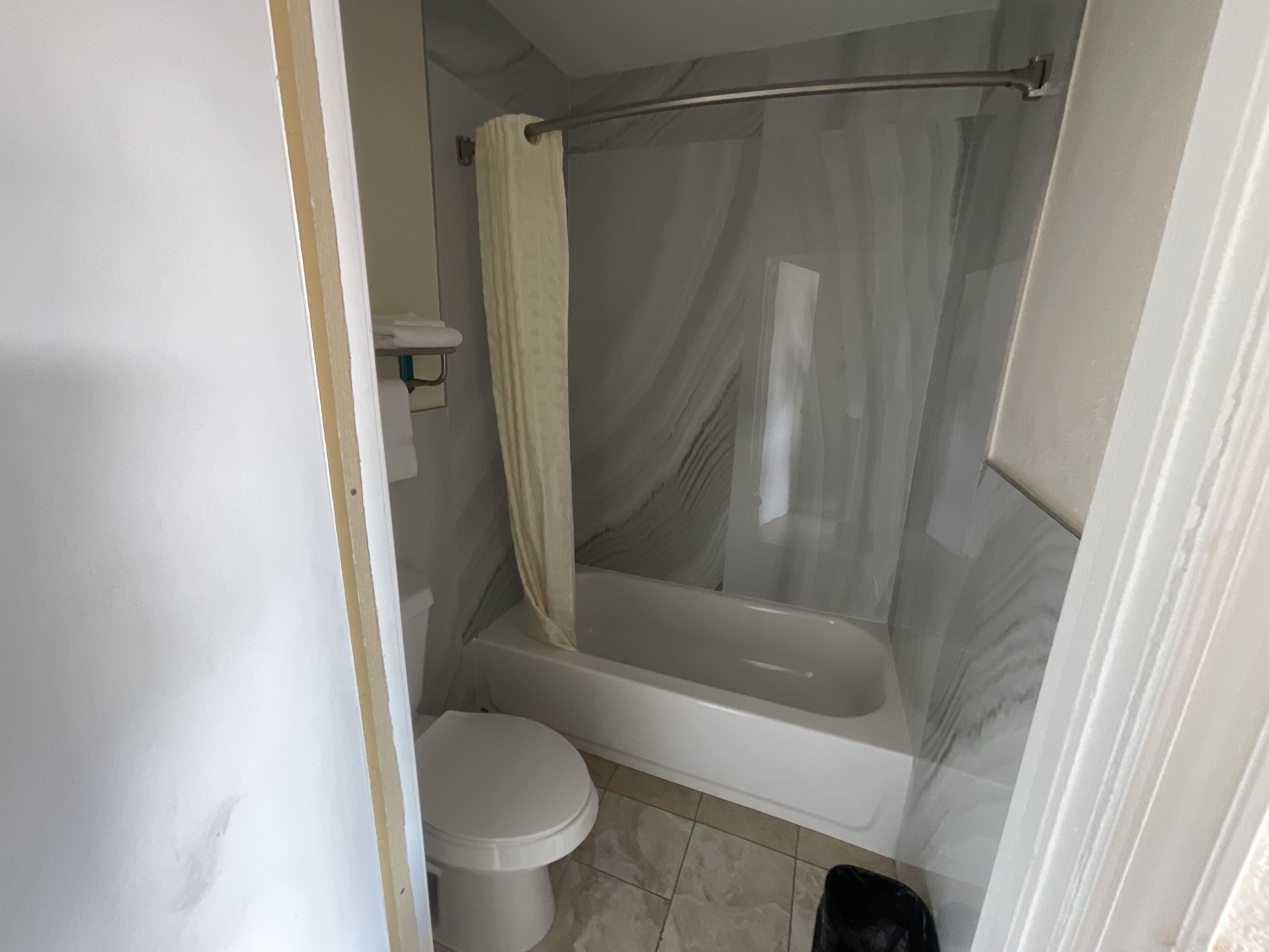 Un baño con inodoro, bañera y cortina de ducha.