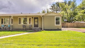 A single-story house with a front porch, a bicycle parked outside, and a basketball hoop in the yard. - Well-Appointed Fruita Townhome: Hike & Bike Nearby (Fruita)