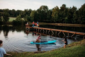 A wooden dock extending over calm water, surrounded by trees.