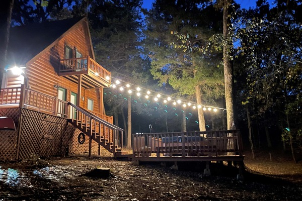 View at night with string lights over the hot tub