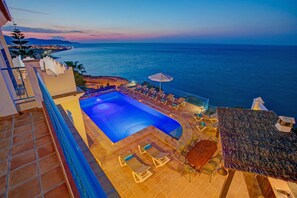 Une piscine sur le toit offrant une vue sur l’océan au crépuscule.