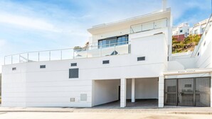 Une villa moderne dotée d’un toit plat, de grandes fenêtres et d’un espace extérieur couvert.
