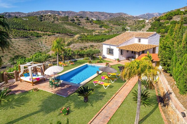 A villa with a swimming pool, outdoor seating, and a view of the surrounding hills. - Villa Paraiso by Villa Plus (Frigiliana)