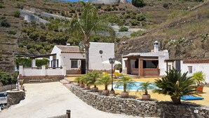 Una propiedad costera con piscina, muros de piedra y vista al mar.