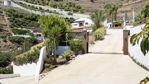 Una zona residencial con un camino de entrada pavimentado que lleva a un acceso con puerta.