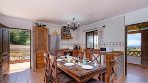 Une cuisine spacieuse avec un coin repas, une cheminée en pierre et une vue sur l’extérieur.