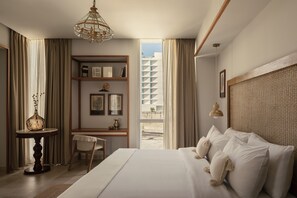 A hotel room with a large bed, a desk with a chair, a bookshelf, and a view of the outside. - Hotel Sureño Yucatán (Mérida)