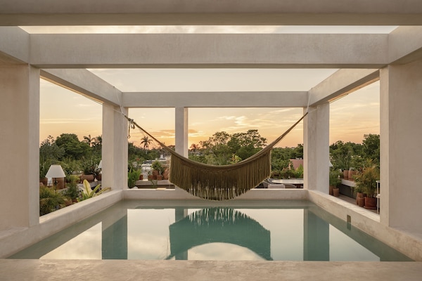 Alberca al aire libre, sombrillas en la alberca y camastros