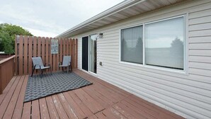 A single-story house with a covered patio area, two chairs, and a sliding glass door. - Updated Twin Home near Sanford Medical Center (West Fargo)