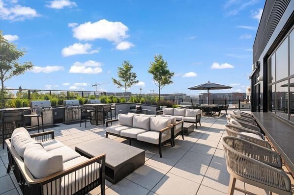 Enjoy panoramic city views from this rooftop terrace with comfortable seating and a communal table.