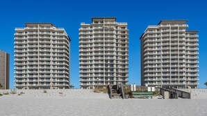 Three high-rise buildings with multiple balconies, a sandy beach in the foreground, and a clear blue sky. - 🌞Beachfront|Gulf Views|Pools|3BR Summerwind 804🌞 (Navarre Beach)