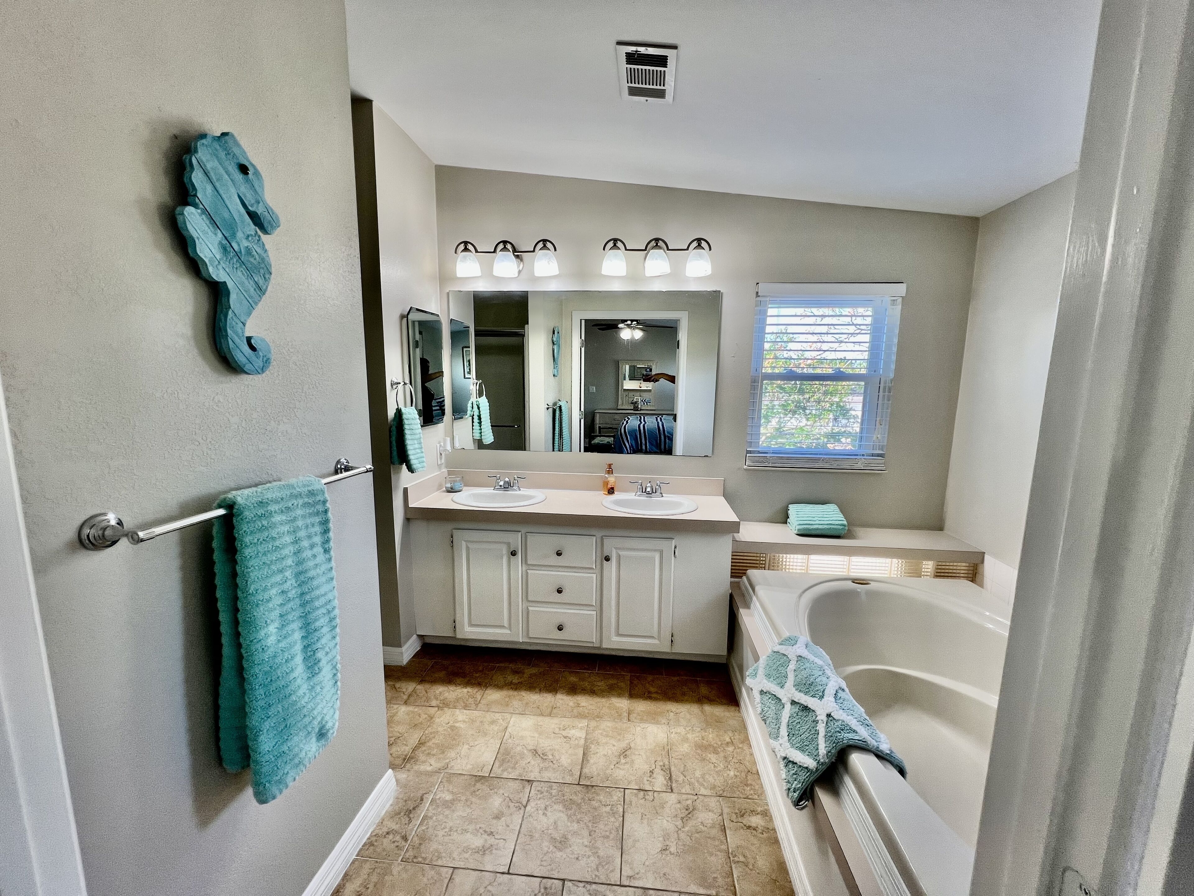 Une salle de bain avec un lavabo, un miroir et une baignoire.