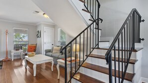 A staircase with black railings and wooden steps, leading to an upper floor. - Beautifully Renovated Waterfront House in Gulfport (Gulfport)