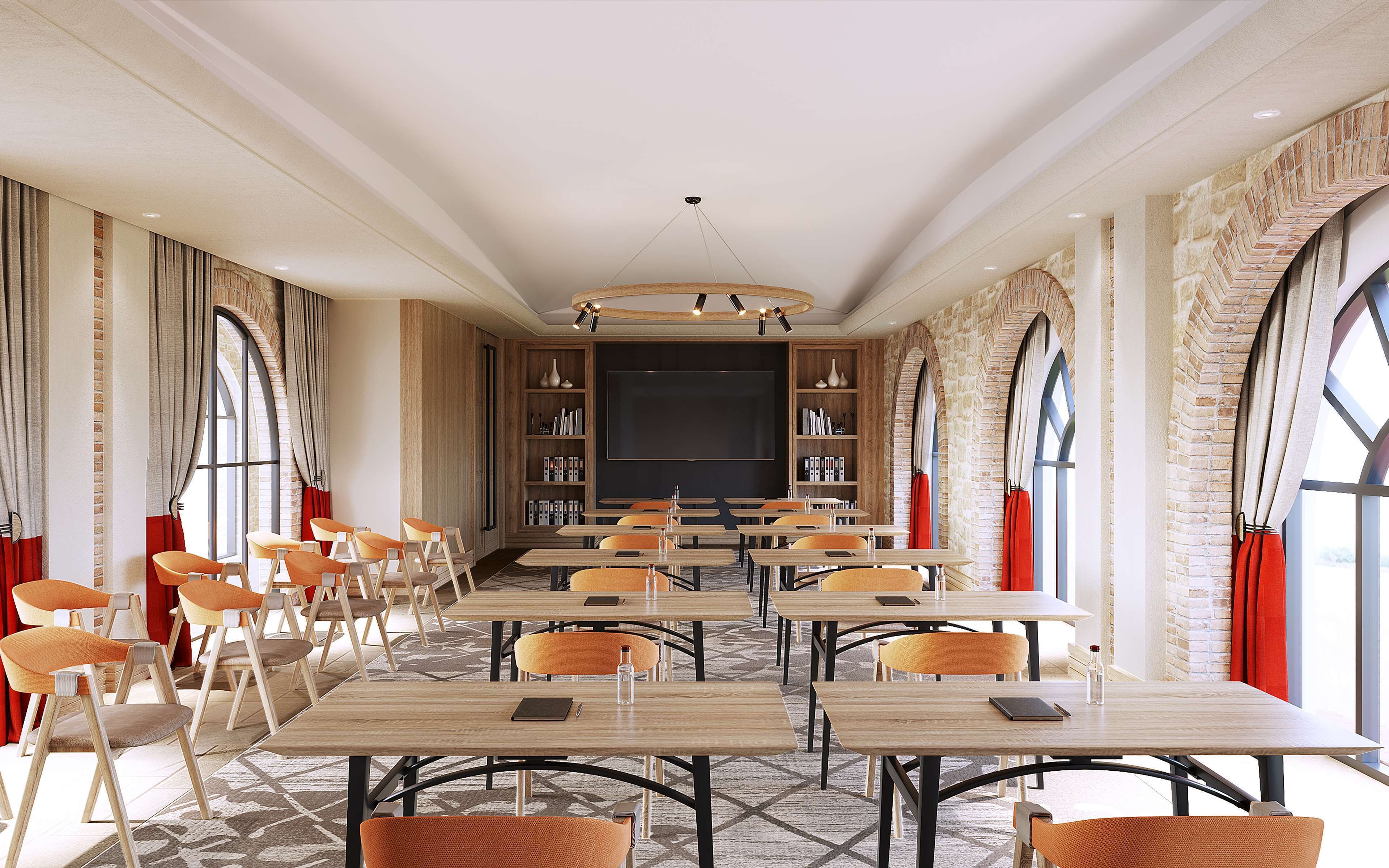 A conference room with a large screen, multiple tables, and chairs.