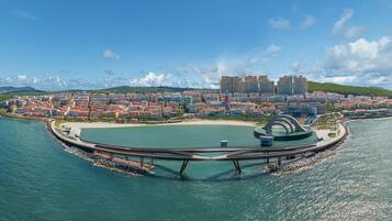 An aerial view of a coastal city with a circular park, a marina, and a mix of residential and commercial buildings.