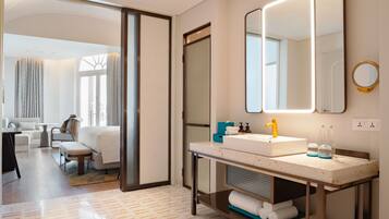 Un baño moderno con un espejo grande, un lavabo blanco y un perchero para toallas.