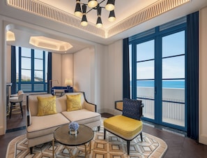 A modern living room with a sofa, armchairs, a coffee table, and a view of the sea. - La Festa Phu Quoc, Curio Collection By Hilton (Phu Quoc)