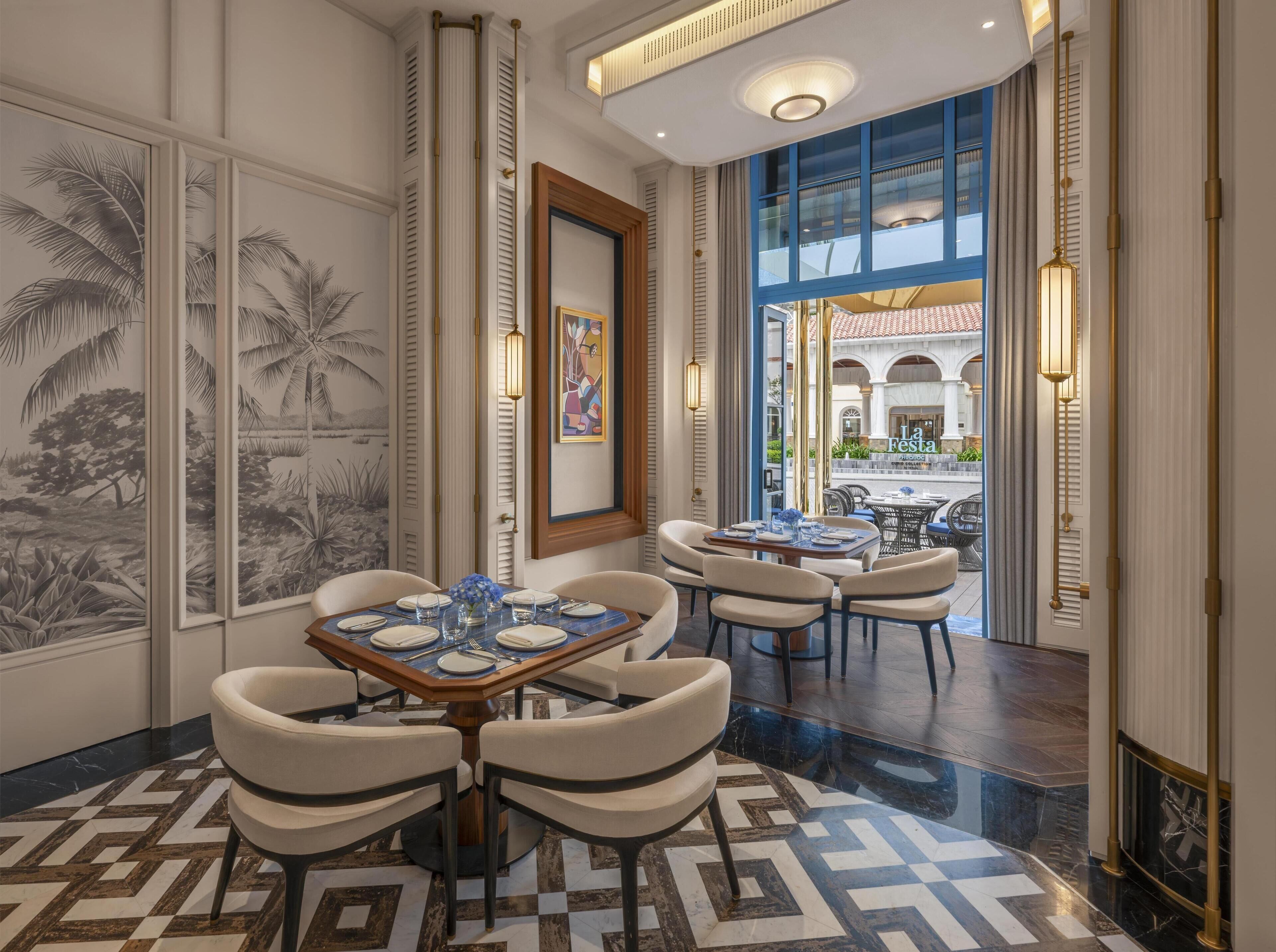 Un comedor con una mesa grande dispuesta para seis personas, rodeada de sillas. Hay un ventanal con vistas a un patio exterior.