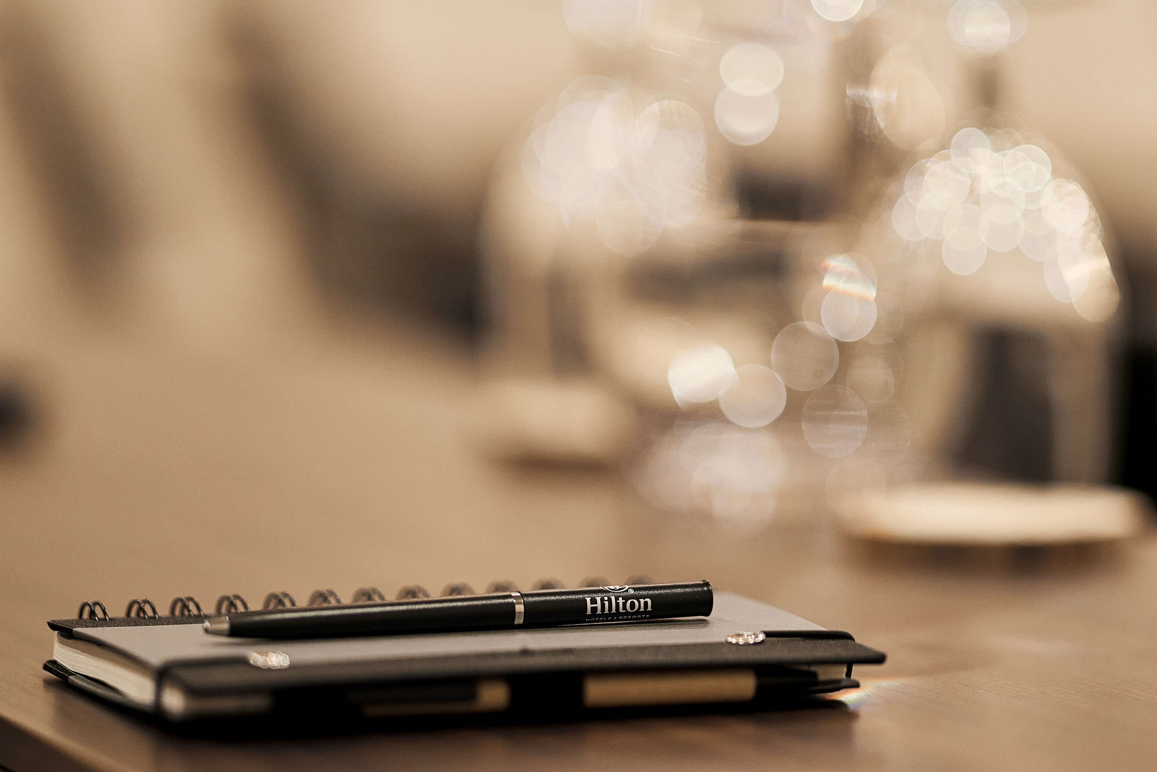 Un carnet et un stylo sur une surface en bois, avec un arrière-plan flou.