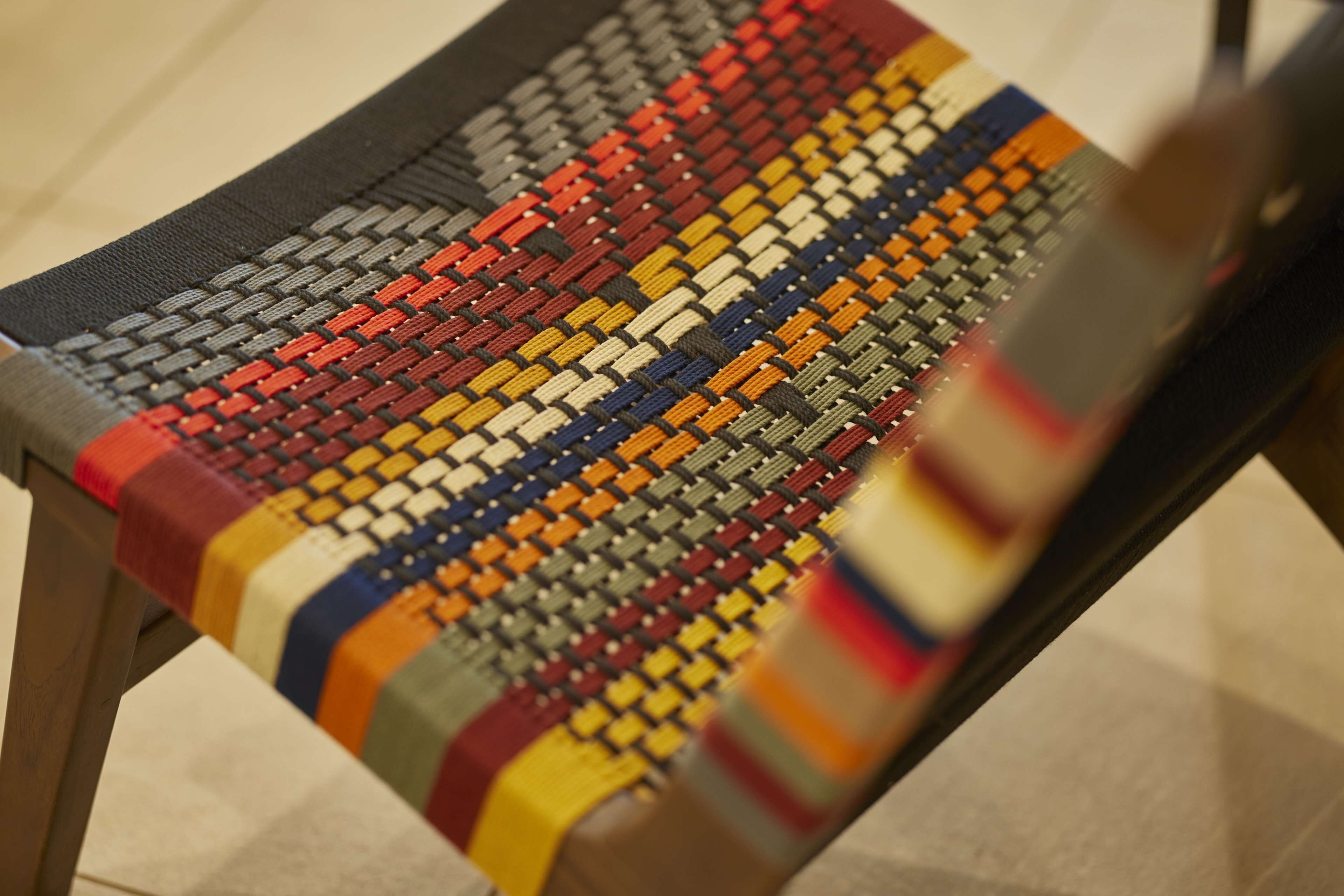 Une chaise en osier avec un motif coloré.