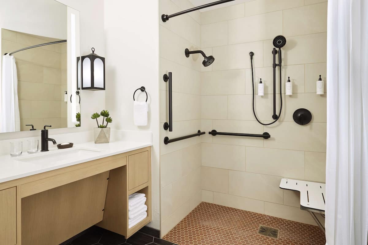 A modern bathroom with a shower, a sink, and a mirror.