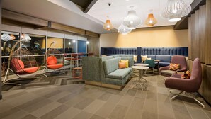 Un'area lounge moderna con divano, poltrone e lampade a sospensione.