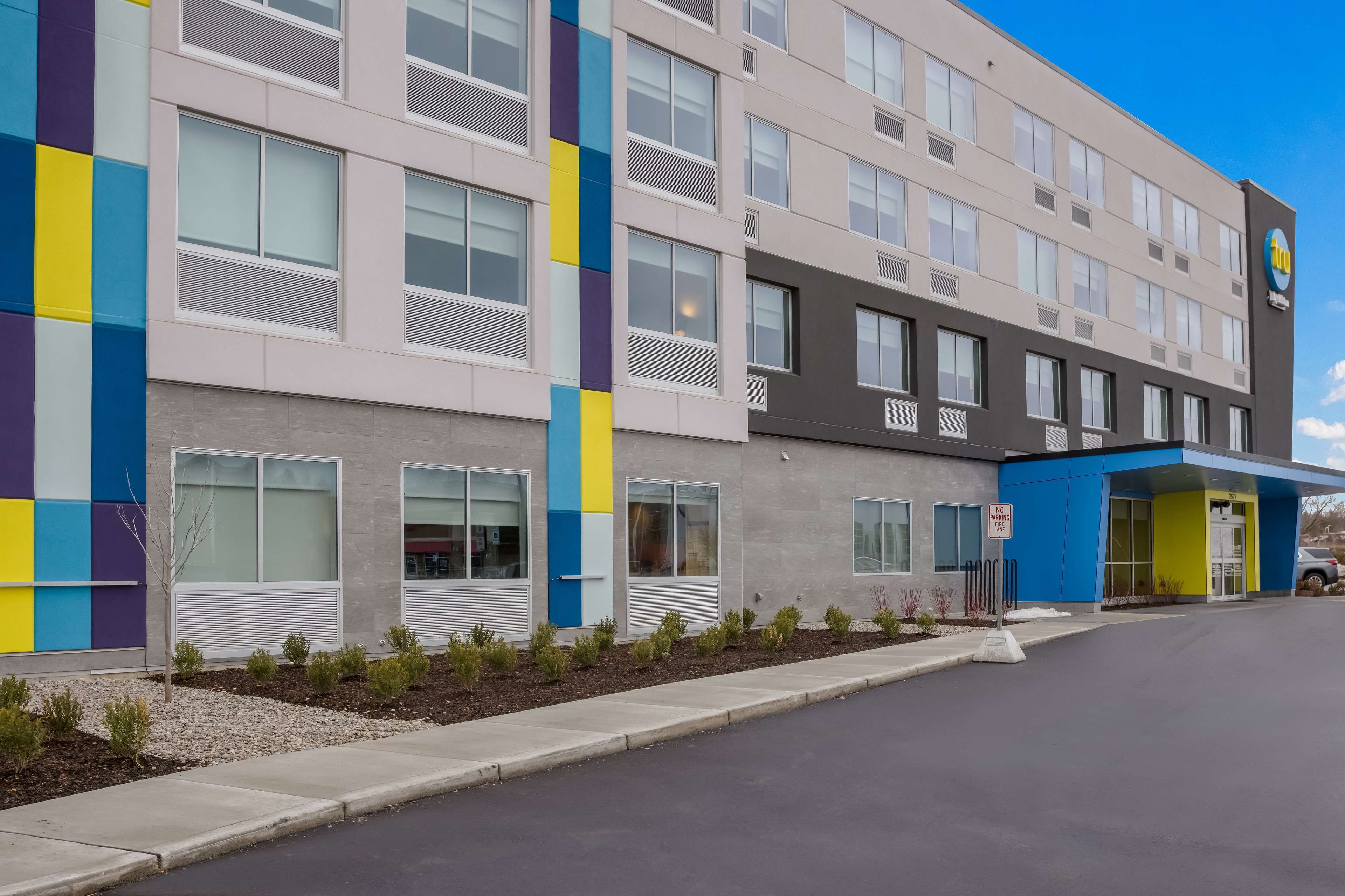 A multi-story hotel with a modern facade, featuring a mix of neutral and vibrant colors.