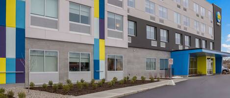 A multi-story hotel with a modern facade, featuring a mix of neutral and vibrant colors.