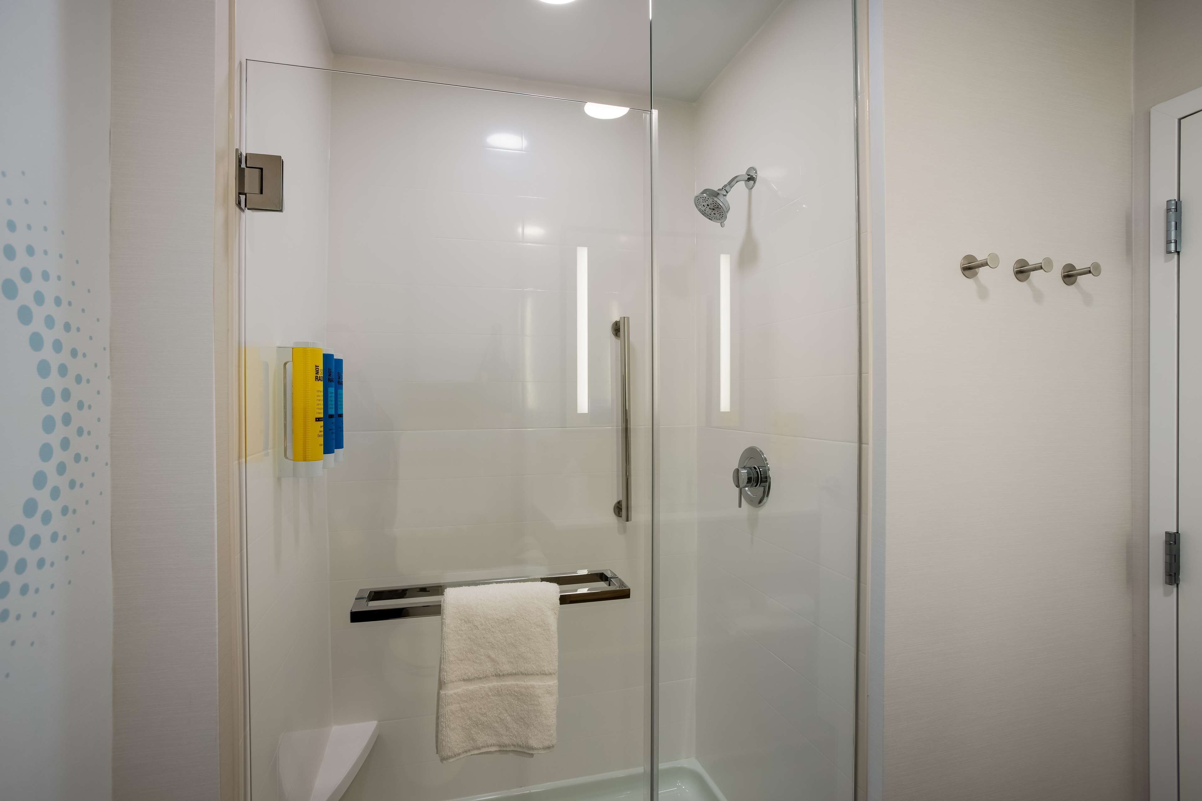 A modern bathroom with a glass shower enclosure, a towel rack, and a toilet.