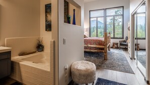 A modern bathroom with a bathtub, a small stool, and a shelf with decorative items. - On Golf Course Fully Renovated Luxury 4 Bedrm 3 Full Bathrms and Half Bath Snowcreek 732 Phase V (Mammoth Lakes)