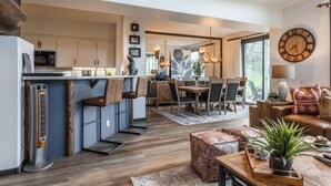 A modern kitchen with a built-in refrigerator, wooden cabinets, and a dining area with a wooden table and chairs. - On Golf Course Fully Renovated Luxury 4 Bedrm 3 Full Bathrms and Half Bath Snowcreek 732 Phase V (Mammoth Lakes)
