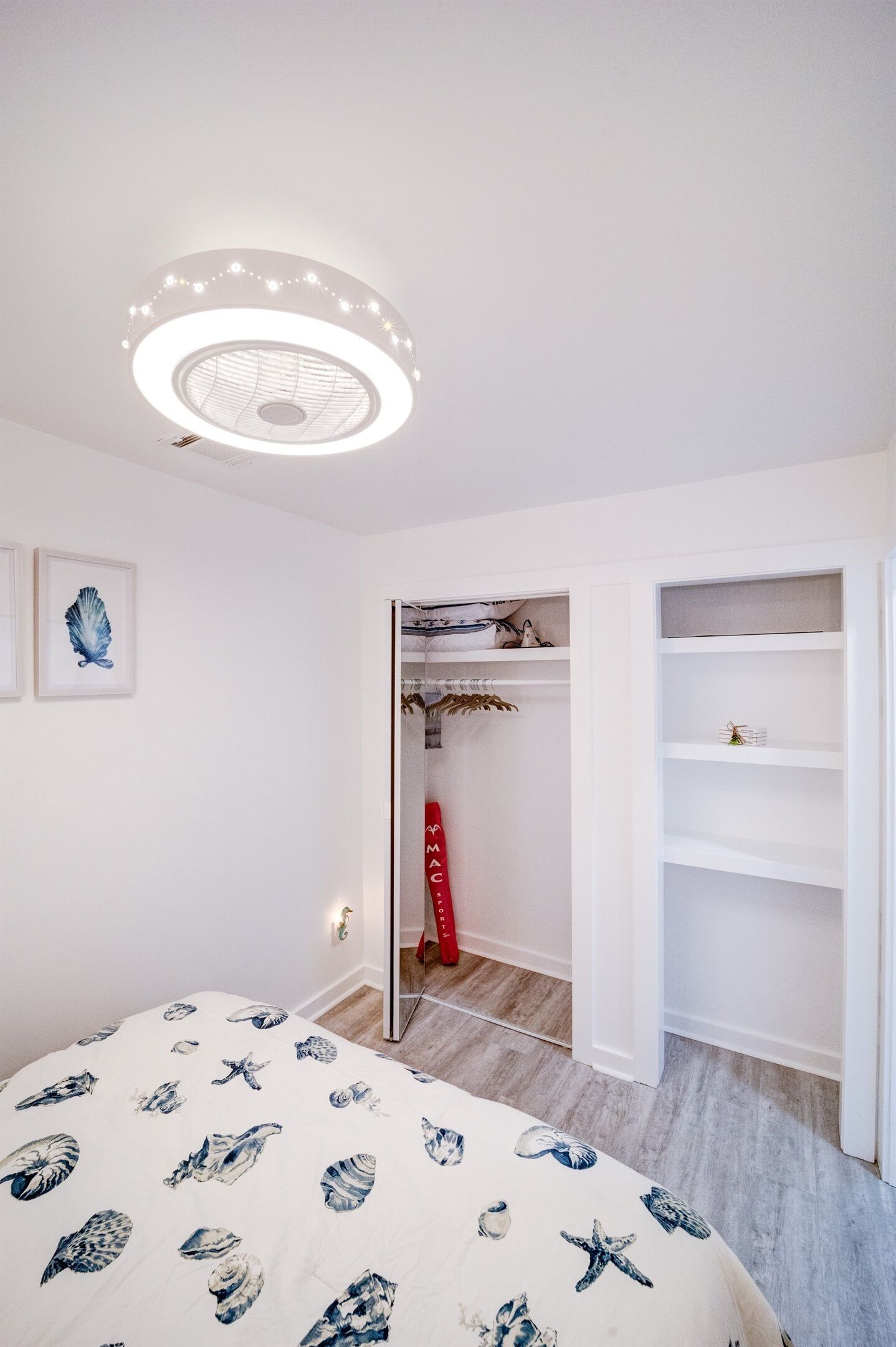 A bedroom with a bed, a closet, and a ceiling light fixture.