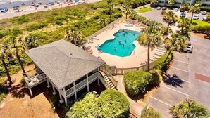 Et resort med swimmingpool, strand og parkeringsplads.