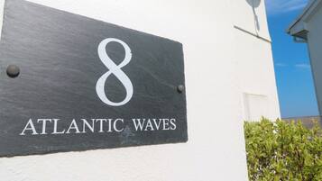 Segnaletica in ardesia con il numero 8 e la scritta 'ATLANTIC WAVES' su una parete bianca.