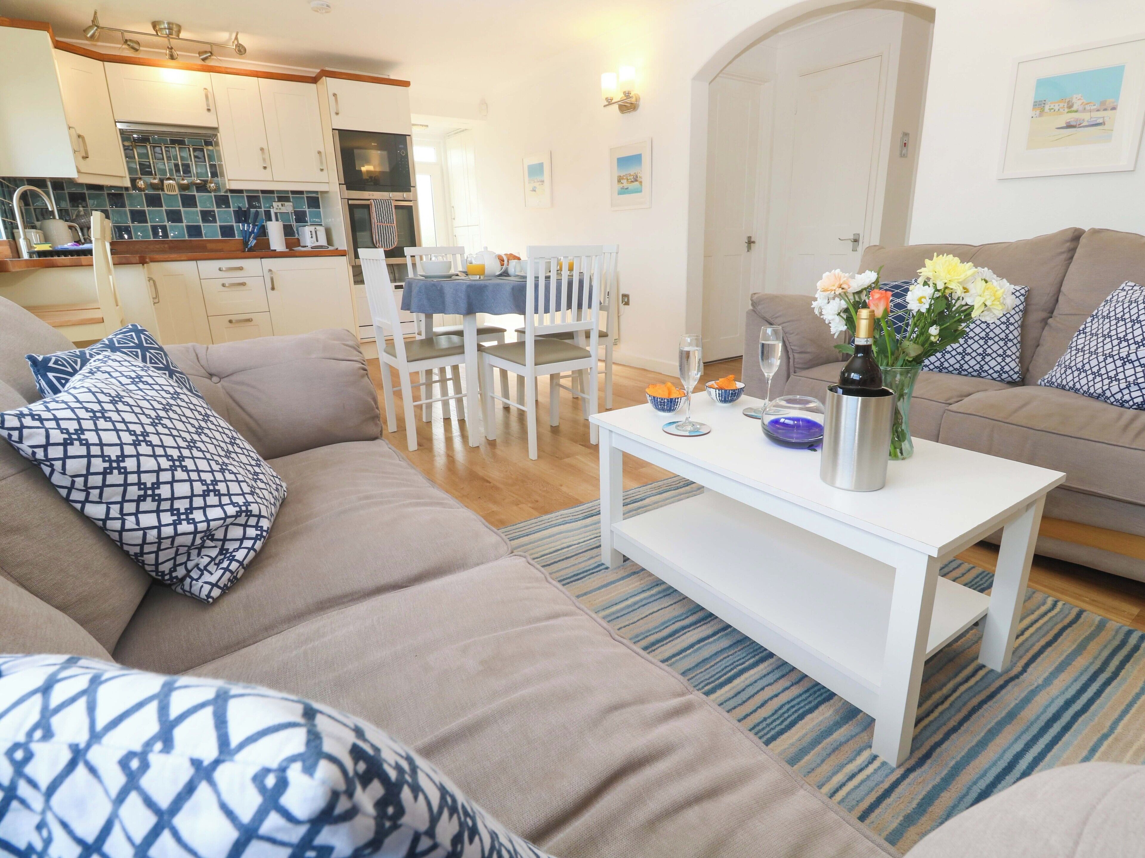 A living room with a sofa, a coffee table, and a dining area with chairs and a table.