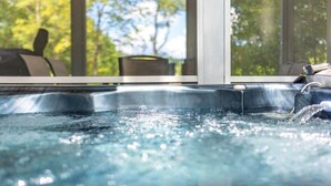 Un jacuzzi con vistas a los árboles a través de una ventana.