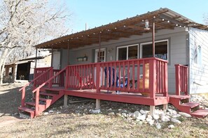 A house with a wooden deck, a covered porch, and a garage.