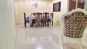 Un comedor con una mesa, sillas, una lámpara de techo y una silla decorativa.