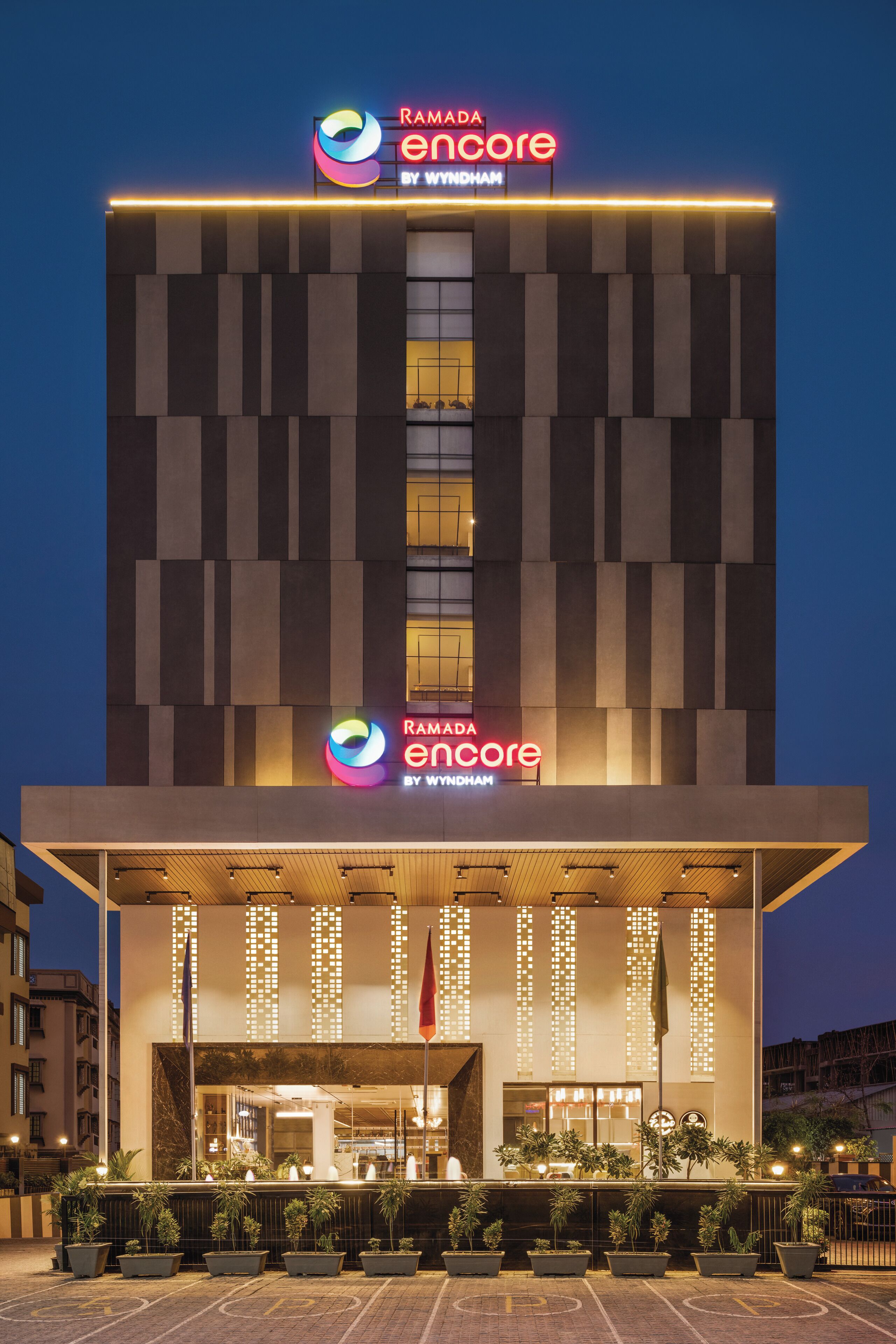 A modern hotel building with a prominent sign reading "Ramada Encore by Wyndham."