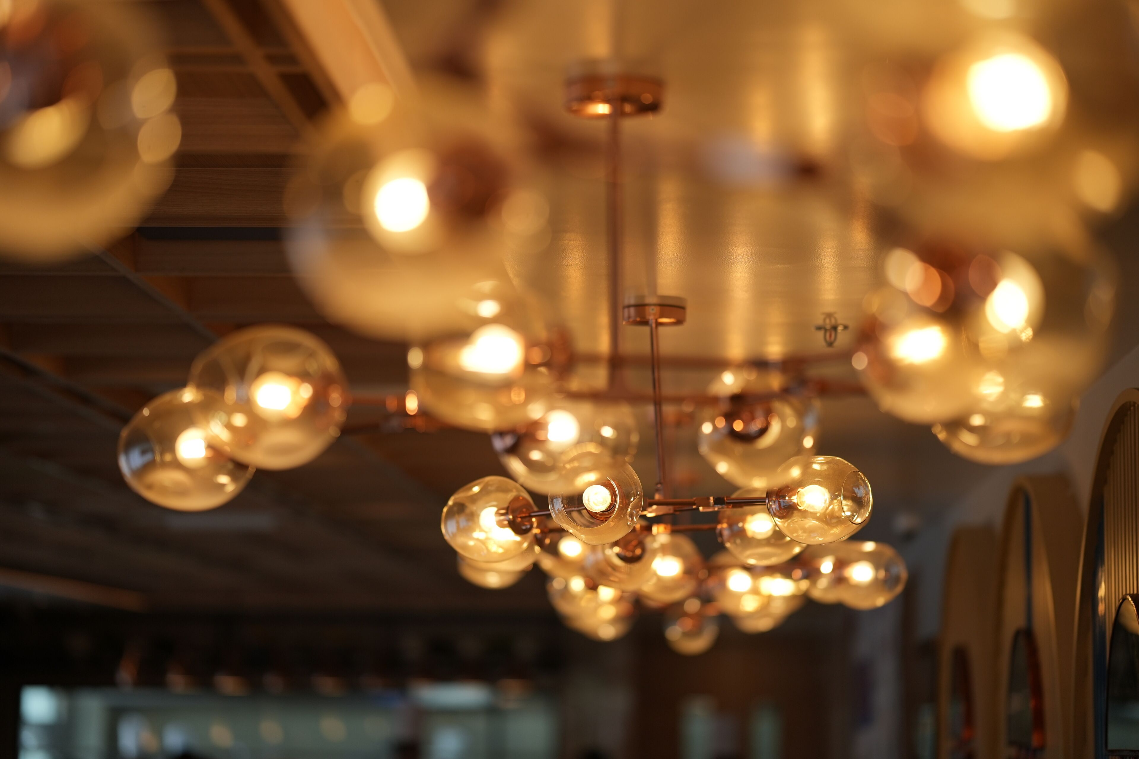 A chandelier with multiple spherical bulbs in a well-lit indoor space.